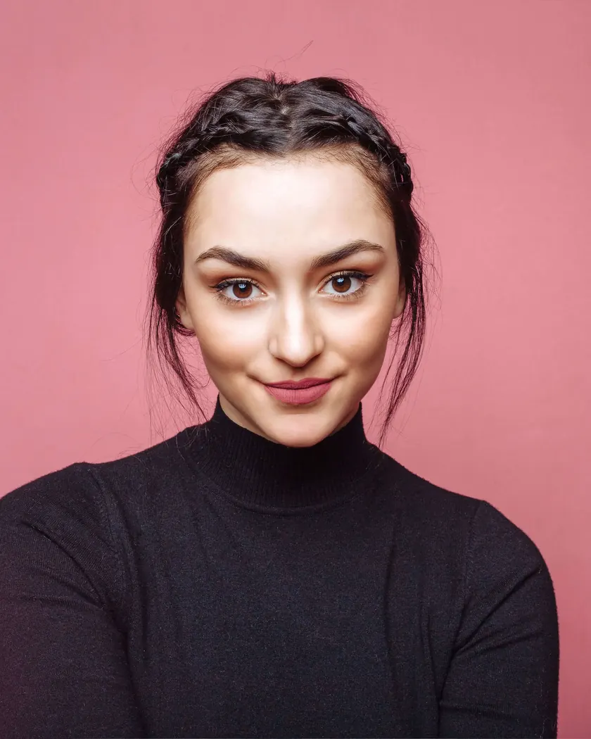 Smiling woman with clear eyes against a pink background